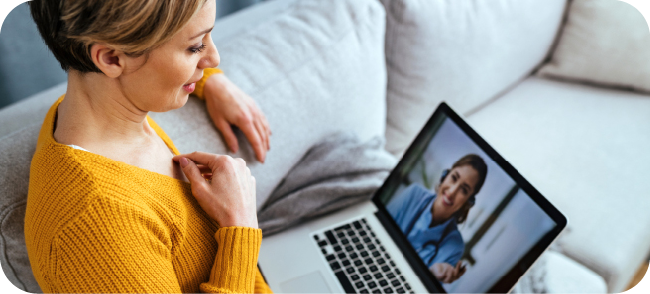 Woman using a laptop for a virtual doctor's appointment from home.