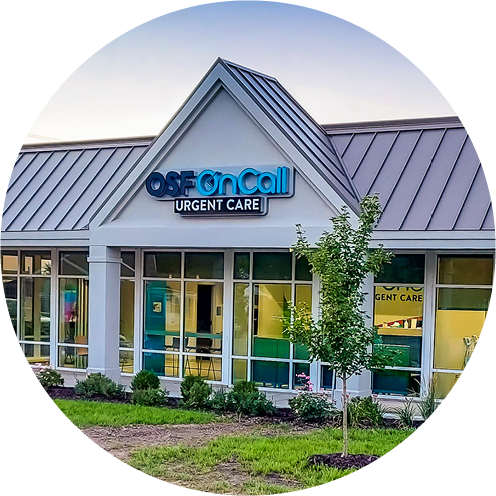 Exterior view of an OSF OnCall Urgent Care clinic featuring a modern white building with large glass windows and a dark grey gabled roof, partially framed within a circular crop.