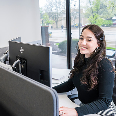 A virtual hospitalist provider communicating with rural hospital staff via a desktop computer and headset.